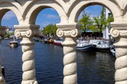 Amsterdam und Umgebung April 2025 Ansicht durch eine verzierte Balustrade auf Amsterdams Grachten und die dort liegenden Boote Amsterdam und Umgebung April 2025 Verzierte Balustrade mit Blick auf Amsterdams Grachten und Boote
