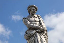 Amsterdam und Umgebung April 2025 Marmornes Denkmal eines historisch bedeutenden Mannes vor blauem Himmel Amsterdam und Umgebung April 2025 Statue eines Mannes mit Hut gegen blauen Himmel