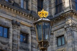 Amsterdam und Umgebung April 2025 Eine kunstvolle Straßenlaterne mit Krone vor einem historischen Gebäude in Amsterdam Amsterdam und Umgebung April 2025 Historische Straßenlaterne mit goldener Krone vor altem Gebäude