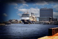 Amsterdam und Umgebung April 2025 Ein Kreuzfahrtschiff liegt vor dem Mövenpick Hotel an einem sonnigen Tag in Amsterdam Amsterdam und Umgebung April 2025 Kreuzfahrtschiff vor dem Mövenpick Hotel in Amsterdam am Kai