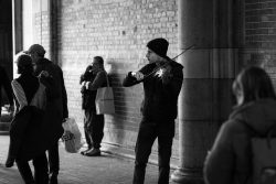 Amsterdam und Umgebung April 2025 Ein Violinist spielt in der Innenstadt und bietet den Passanten eine musikalische Darbietung Amsterdam und Umgebung April 2025 Straßenmusiker spielt Violine in urbaner Umgebung mit Passanten