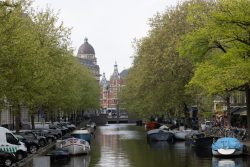 Amsterdam und Umgebung April 2025 Ein ruhiger Kanal in Amsterdam, gesäumt von Booten und üppigen Bäumen im Frühling Amsterdam und Umgebung April 2025 Amsterdamer Kanal mit Booten und Bäumen im Frühling