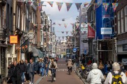 Amsterdam und Umgebung April 2025 Passanten und Fahrradfahrer in einer lebhaften Straße von Amsterdam Amsterdam und Umgebung April 2025 Belebte Einkaufsstraße in Amsterdam mit Fahrradfahrern und Passanten