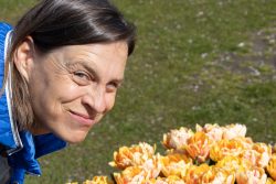 Amsterdam und Umgebung April 2025 Frau genießt den Frühling neben einem lebhaften Tulpenbeet Amsterdam und Umgebung April 2025 Frau im Freien lächelt neben einem Tulpenbeet