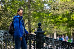 Amsterdam und Umgebung April 2025 Ein Spaziergang auf einer Brücke im Park Amsterdam und Umgebung April 2025 Person in blauer Jacke auf einer Brücke im sonnigen Park