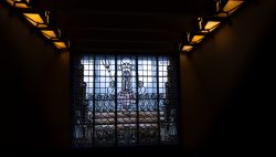 Amsterdam und Umgebung April 2025 Ein kunstvoll gestaltetes Buntglasfenster in einem dunklen Innenraum Amsterdam und Umgebung April 2025 Buntglasfenster mit religiösem Motiv, Innenaufnahme