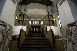 Amsterdam und Umgebung April 2025 Ein beeindruckender Art-Deco-Treppenaufgang mit stilvollen Lichtelementen Amsterdam und Umgebung April 2025 Art-Deco-Treppe mit Marmordetails und eleganten Leuchten im Eingangsbereich