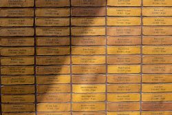 Amsterdam und Umgebung April 2025 Ziegelwand mit Gravuren zur Erinnerung an Namen und Daten Amsterdam und Umgebung April 2025 Gelbe Ziegelwand mit eingravierten Namen in deutschsprachigen Kontext