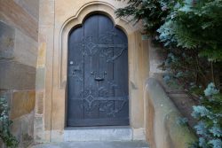 Bamberg - Bamberg Weihnachtsmarkt 2023 Eine kunstvoll gestaltete Tür in einem historischen Gebäude Bamberg - Bamberg Weihnachtsmarkt 2023 Alte Holztür mit verziertem Schmiedeeisen in Steinbogenrahmen