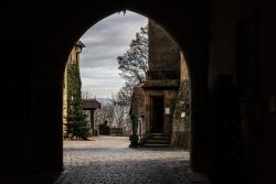 Bamberg - Bamberg Weihnachtsmarkt 2023 Ein Durchgang führt vom Schatten eines alten Torgewölbes zu einem idyllischen gepflasterten Hof Bamberg - Bamberg Weihnachtsmarkt 2023 Mittelalterliches Torbogen mit Blick auf gepflasterten Hof und Bäume