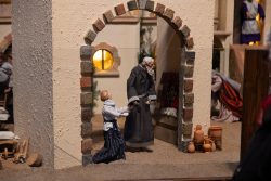 Bamberg - Bamberg Weihnachtsmarkt 2023 Zwei Figuren unter einem Torbogen in einer traditionellen Weihnachtskrippe Bamberg - Bamberg Weihnachtsmarkt 2023 Weihnachtliche Krippe mit zwei Figuren unter einem Torbogen