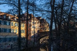 Bamberg - Bamberg Weihnachtsmarkt 2023 Golden schimmernde Altstadtgebäude in Bamberg am Abend Bamberg - Bamberg Weihnachtsmarkt 2023 Altstadtgebäude und Bäume bei Sonnenuntergang in Graz