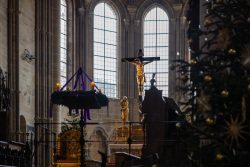 Bamberg - Bamberg Weihnachtsmarkt 2023 Der Bamberger Dom ist weihnachtlich geschmückt, mit einem Kruzifix im Mittelpunkt. Bamberg - Bamberg Weihnachtsmarkt 2023 Gotische Kathedrale mit Kruzifix und Weihnachtsschmuck in Innenansicht