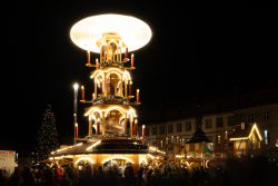 Bamberg - Bamberg Weihnachtsmarkt 2023 Eine große beleuchtete Weihnachtspyramide, die Besucher auf einem deutschen Weihnachtsmarkt bestaunen Bamberg - Bamberg Weihnachtsmarkt 2023 Beleuchtete Weihnachtspyramide auf einem deutschen Weihnachtsmarkt