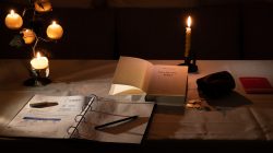 Fotografie von Aloys Peter Trenz Gemütlicher Schreibtisch mit Kerzen, Notizbuch und offenem Buch bei Kerzenlicht Ausgewählte Fotomotive von Aloys Peter Trenz
