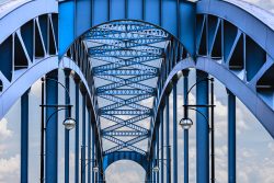 Fotografie von Aloys Peter Trenz Blaue Stahlbrücke mit symmetrischem Bogen und Laternen Ausgewählte Fotomotive von Aloys Peter Trenz