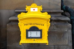 Fotografie von Aloys Peter Trenz Gelber antiker Postbriefkasten an einer steinernen Wand Ausgewählte Fotomotive von Aloys Peter Trenz