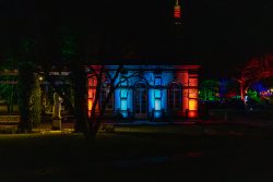 Frankfurt Palmengarten Winterlichter 2025 Nachtaufnahme eines Gebäudes mit bunter Beleuchtung in einem Garten