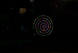 Frankfurt Palmengarten Winterlichter 2025 Bunte Lichtspirale mit Stadtlichtern im Hintergrund