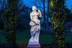 Frankfurt Palmengarten Winterlichter 2025 Klassische Marmorskulptur in einem nächtlichen Garten mit blauen Himmel
