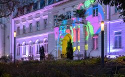 Frankfurt Palmengarten Winterlichter 2025 Historisches Gebäude erleuchtet mit bunten Lichtprojektionen bei Nacht