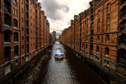 Hamburg Architekturfotografie und Hafen Februar 2024 Historische Speicherstadt in Hamburg mit Kanal und vorbeifahrendem Boot