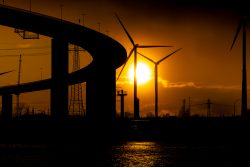 Hamburg Architekturfotografie und Hafen Februar 2024 Windkraftanlagen bei Sonnenuntergang mit Brückensilhouette im Vordergrund