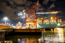 Hamburg Architekturfotografie und Hafen Februar 2024 Containerterminal im Hafen bei Nacht mit beleuchtetem Containerschiff und Kränen