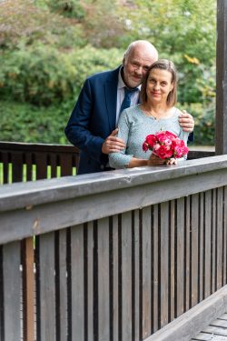 Hochzeitsfotografie Älteres Paar auf Holzbrücke mit Blumenstrauß