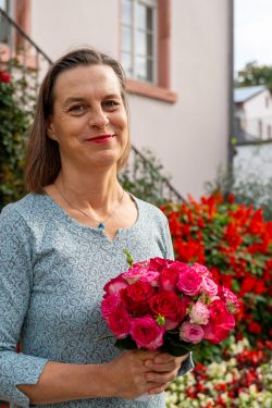 Hochzeitsfotografie Frau mit Blumenstrauß vor blühendem Garten