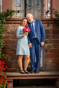 Hochzeitsfotografie Älteres Paar in eleganter Kleidung mit Blumenstrauß