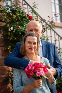 Hochzeitsfotografie Älteres Paar mit Blumenstrauß im Garten vor einem Haus