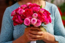 Hochzeitsfotografie Frau hält Strauß aus rosa und roten Rosen