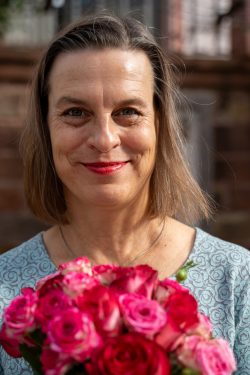 Hochzeitsfotografie Frau mit Blumenstrauß aus rosa und roten Rosen lächelnd