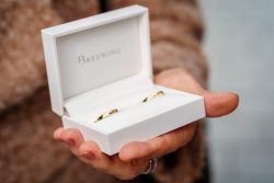 Hochzeitsfotografie Zwei goldene Eheringe in weißer Schmuckschatulle