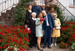 Hochzeitsfotografie Gruppe älterer Menschen bei einer Hochzeit vor rotem Blumenbeet