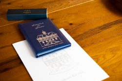 Hochzeitsfotografie Blaues Sammelbuch auf Tisch mit Stift und Dokument