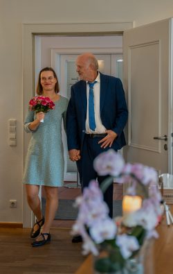 Hochzeitsfotografie Lächelndes Paar betritt Raum bei ihrer standesamtlichen Trauung
