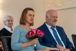 Hochzeitsfotografie Älteres Paar bei ihrer Hochzeit, sitzend mit Blumenstrauß