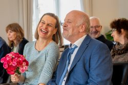 Hochzeitsfotografie Fröhliches Paar bei einer Hochzeitszeremonie mit Blumenstrauß