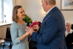 Hochzeitsfotografie Paar tauscht Eheringe während einer Zeremonie im Wohnzimmer