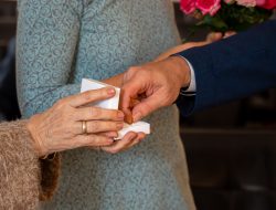 Hochzeitsfotografie Nahaufnahme zweier Hände, die einen Verlobungsring in einer Schachtel halten