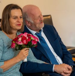 Hochzeitsfotografie Älteres Paar in formeller Kleidung mit Blumenstrauß