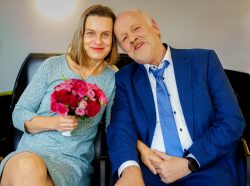 Hochzeitsfotografie Älteres Paar in eleganter Kleidung, Frau hält Rosenstrauß