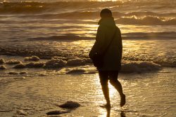 Insel Sylt Februar 2025 Eine Person genießt einen Spaziergang bei Sonnenuntergang am Strand Insel Sylt Februar 2025 Person im Sonnenuntergang am Meer spazierend