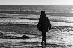 Insel Sylt Februar 2025 Eine Person genießt einen Spaziergang am kalten Strand Insel Sylt Februar 2025 Person beim Spaziergang am winterlichen Ozeanstrand