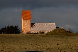 Insel Sylt Februar 2025 Die beeindruckende Backsteinkirche St. Clemens auf der Insel Fårö, beleuchtet vom Abendlicht Insel Sylt Februar 2025 Historische Backsteinkirche St. Clemens auf Insel Fårö, umgeben von Feld