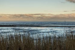 Insel Sylt Februar 2025 Ein malerischer Blick über das Wattenmeer bei Sonnenuntergang Insel Sylt Februar 2025 Küstenlandschaft bei Sonnenuntergang mit Watt und Ferne Brücke