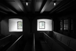 Insel Sylt Februar 2025 Ein Blick in den Innenraum einer historischen Kirche mit Fensterlicht Insel Sylt Februar 2025 Historischer Kircheninnenraum mit beleuchteten Bänken und zwei Fenstern