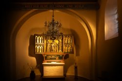 Insel Sylt Februar 2025 Ein kunstvoll gestalteter Altar, der die spirituelle Atmosphäre der Kirche betont Insel Sylt Februar 2025 Beleuchteter Kirchenaltar mit dekorativem Kronleuchter in historischem Kirchenraum